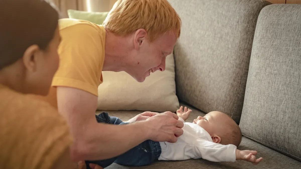 Parent jouer avec tout-petit dans les bras bébé fils à la maison en vacances. Famille, père, fils, bébé, heureux, concept de mode de vie.
