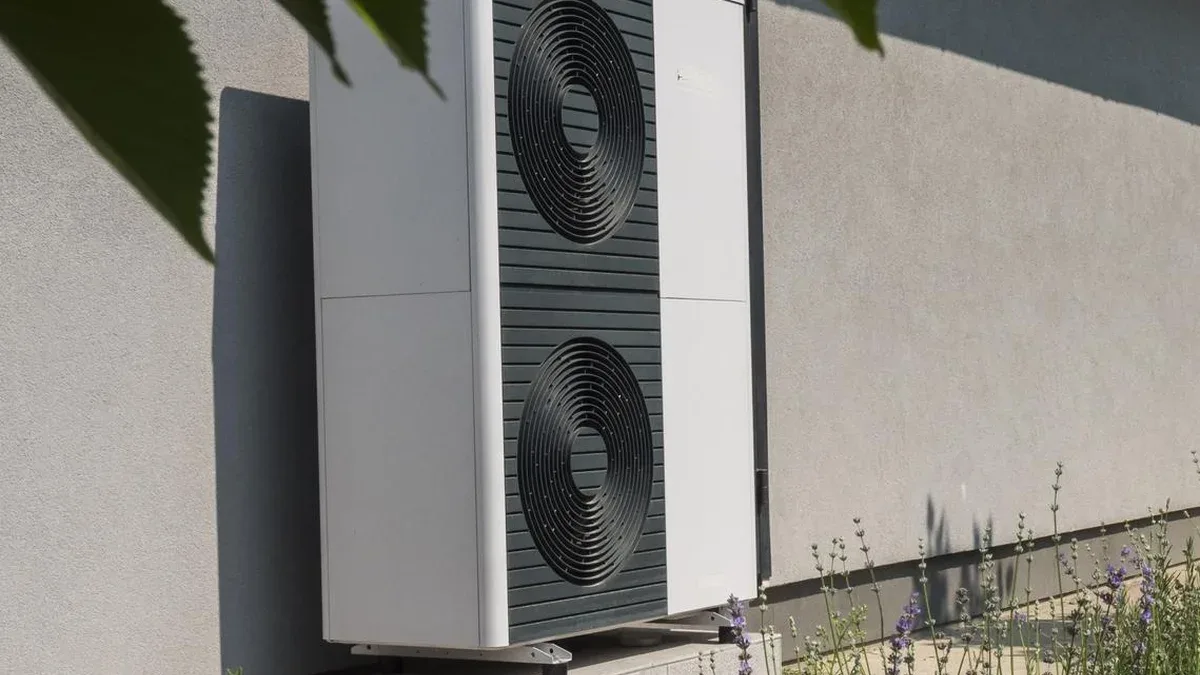 Unité de pompe à chaleur externe contre le mur de la maison Technologies modernes pour l'économie d'énergie