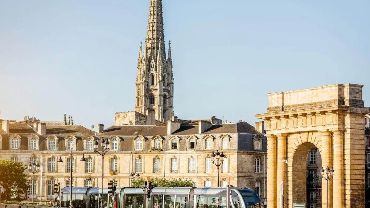 Vue sur la mer sur les célèbres portes de Bourgogne et la tour de la cathédrale Saint Michel pendant la lumière du matin dans la ville de Bordeaux, France