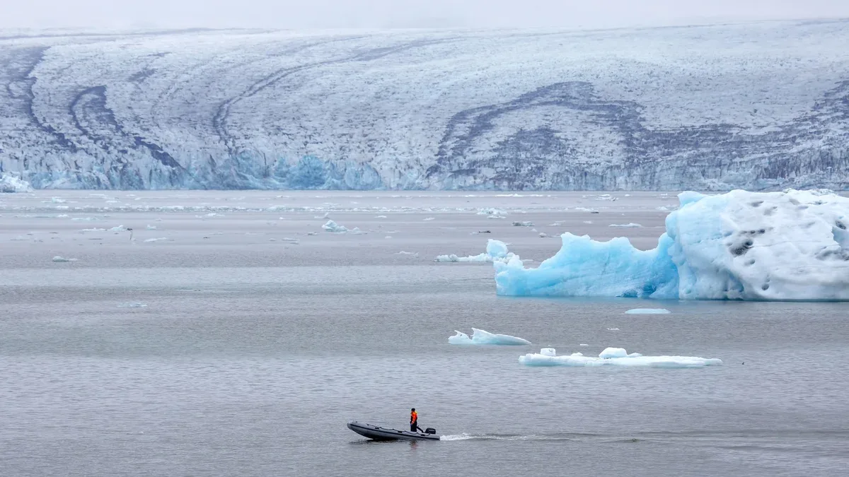 Homme sur un bateau à moteur rapide naviguant sur une lagune glaciaire en Islande