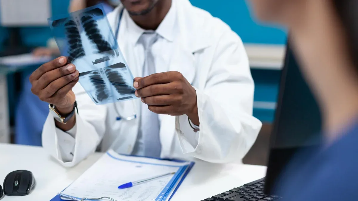 Gros plan d'un médecin pédiatre afro-américain tenant une radiographie pulmonaire expliquant l'expertise en radiographie à la mère du patient discutant du traitement médical dans le bureau de l'hôpital. Service de soins de santé