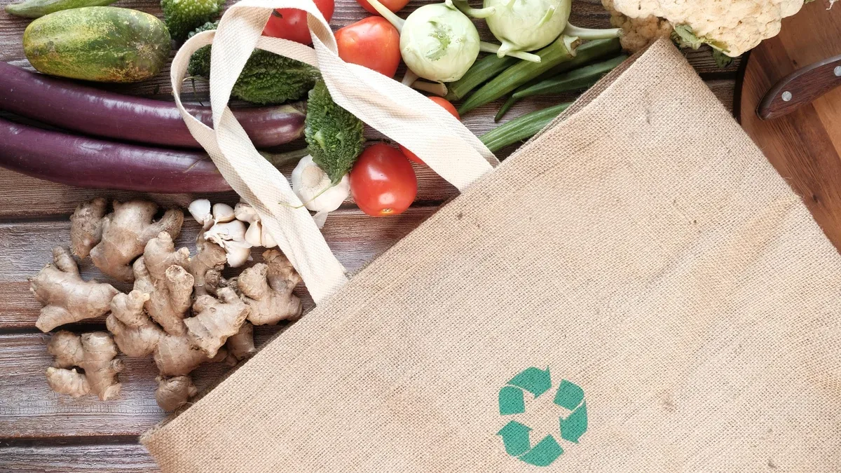 Sac à provisions réutilisable avec signe de flèches recyclées et légumes sur table